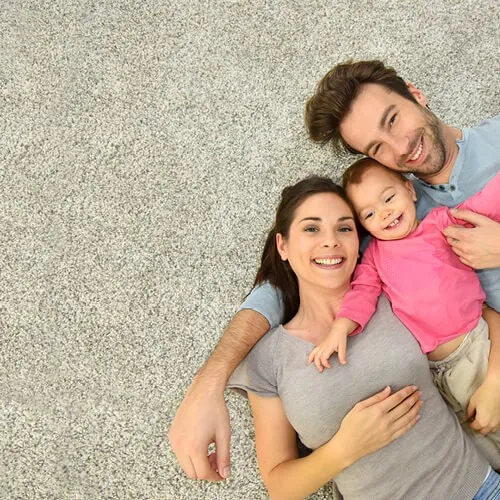 Happy Family laying on grey soft carpet | Jubilee Flooring & Decorating